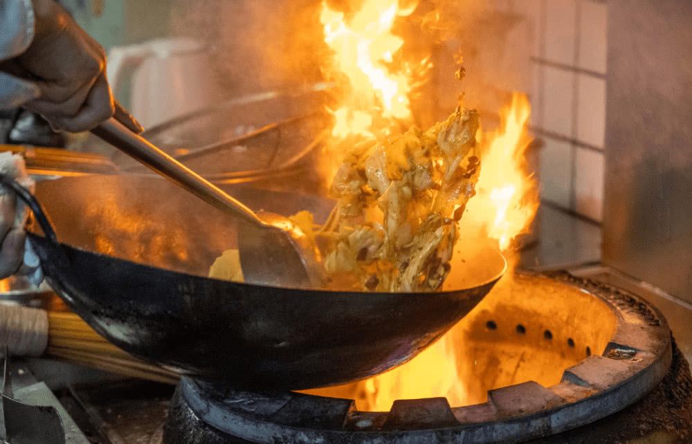 4月2日,在武汉市江岸区武汉天地商业街一饭店,厨师在后厨做菜.